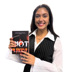 Author Alia holding her book Riot, distributed by The Africa Stand