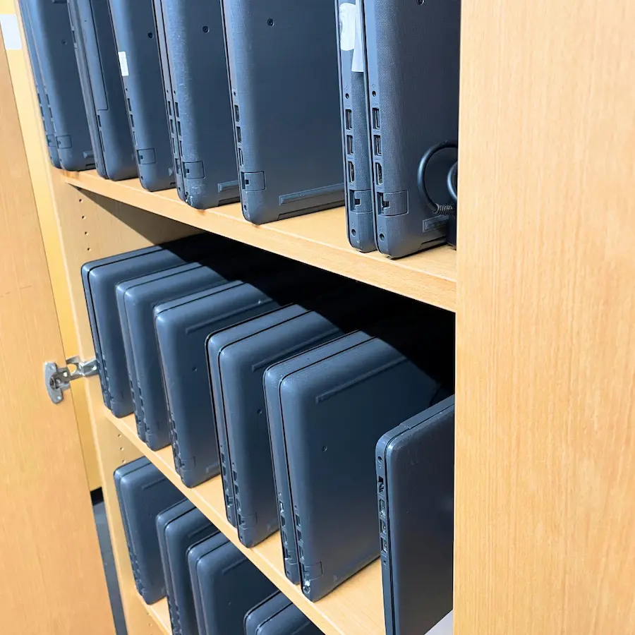 Donated laptops on a shelf, refurbished for schools in Africa