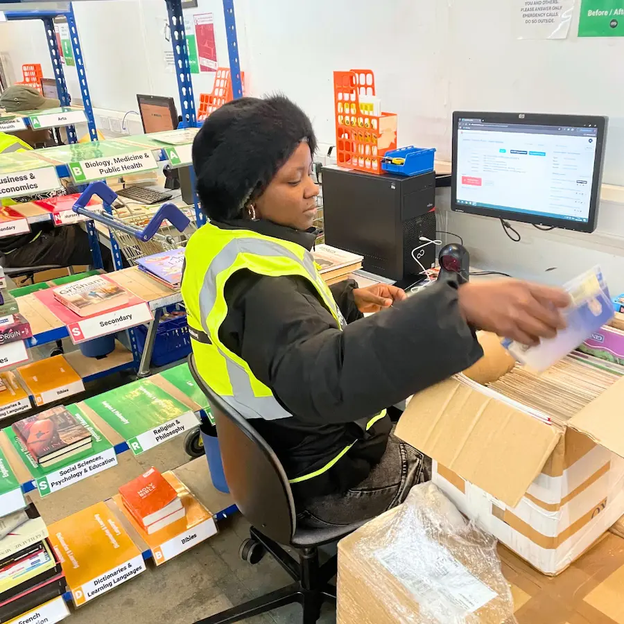 Volunteer in a hi-vis vest sorting donated books